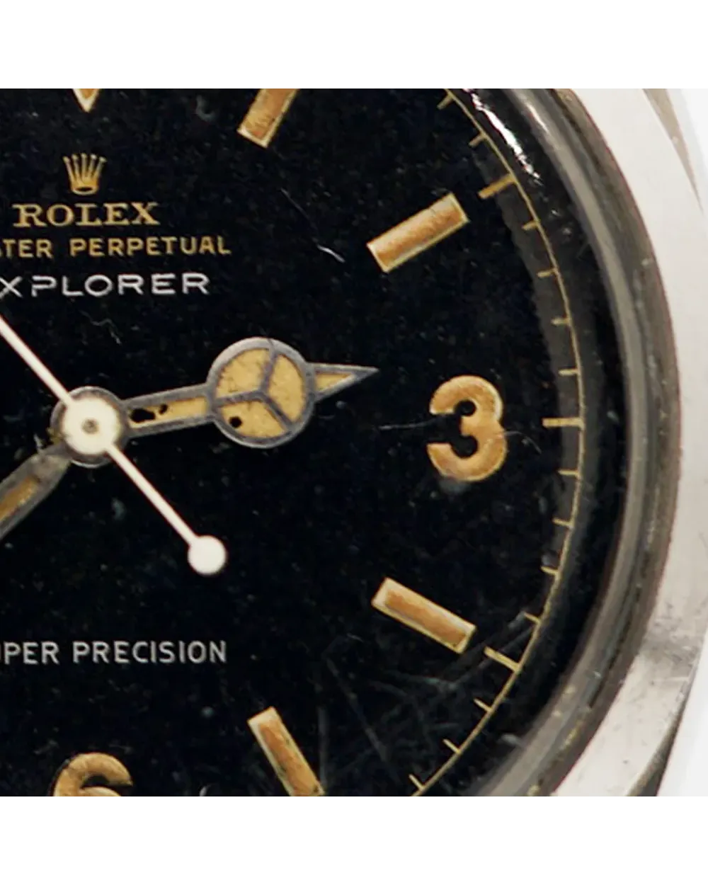 Dial detail of a Rolex Explorer 5504 showing tropical patina, gilt Mercedes hands, and cream hour markers.