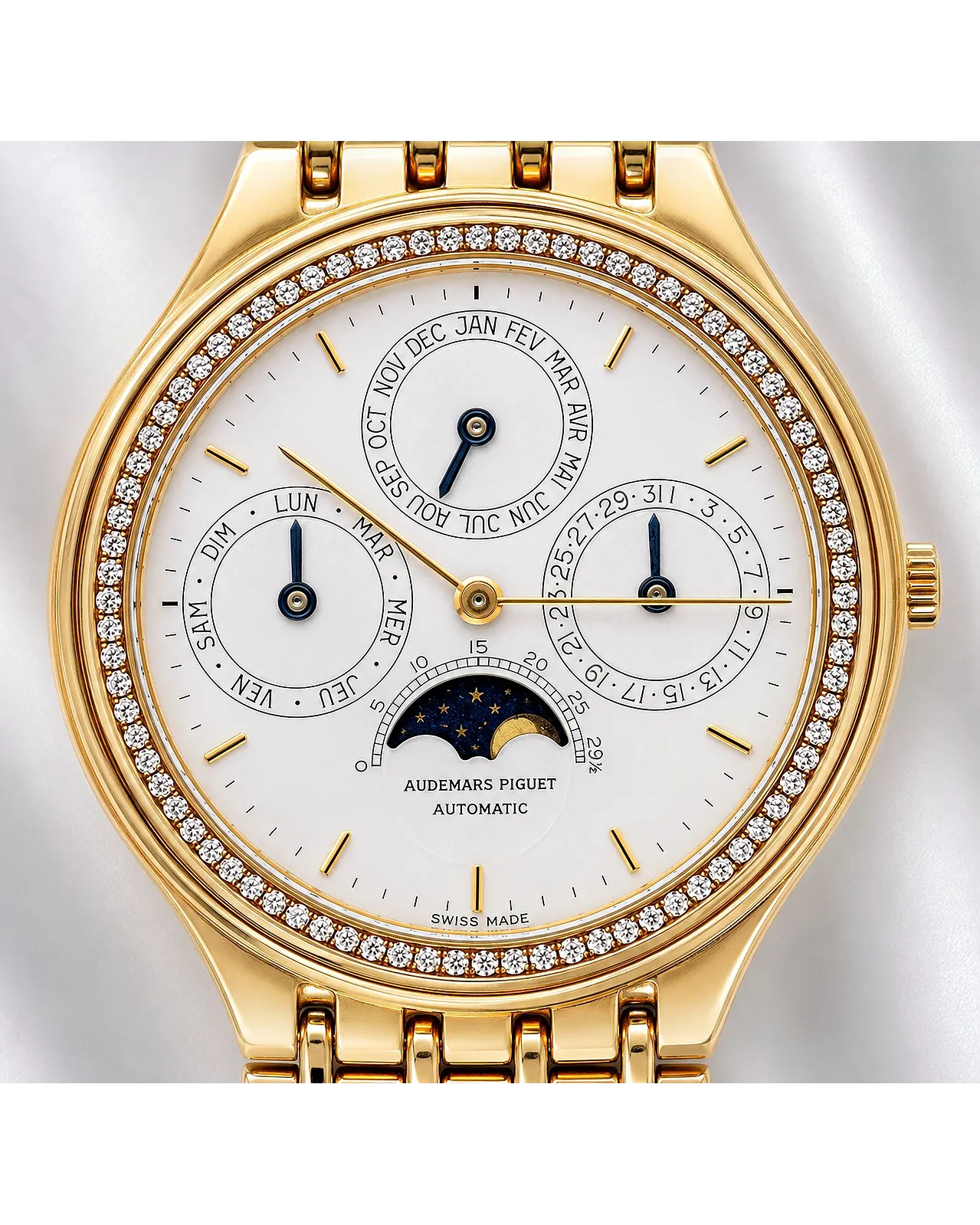 Dial detail of an Audemars Piguet automatic perpetual calendar moon phase watch in yellow gold with diamond-set bezel.