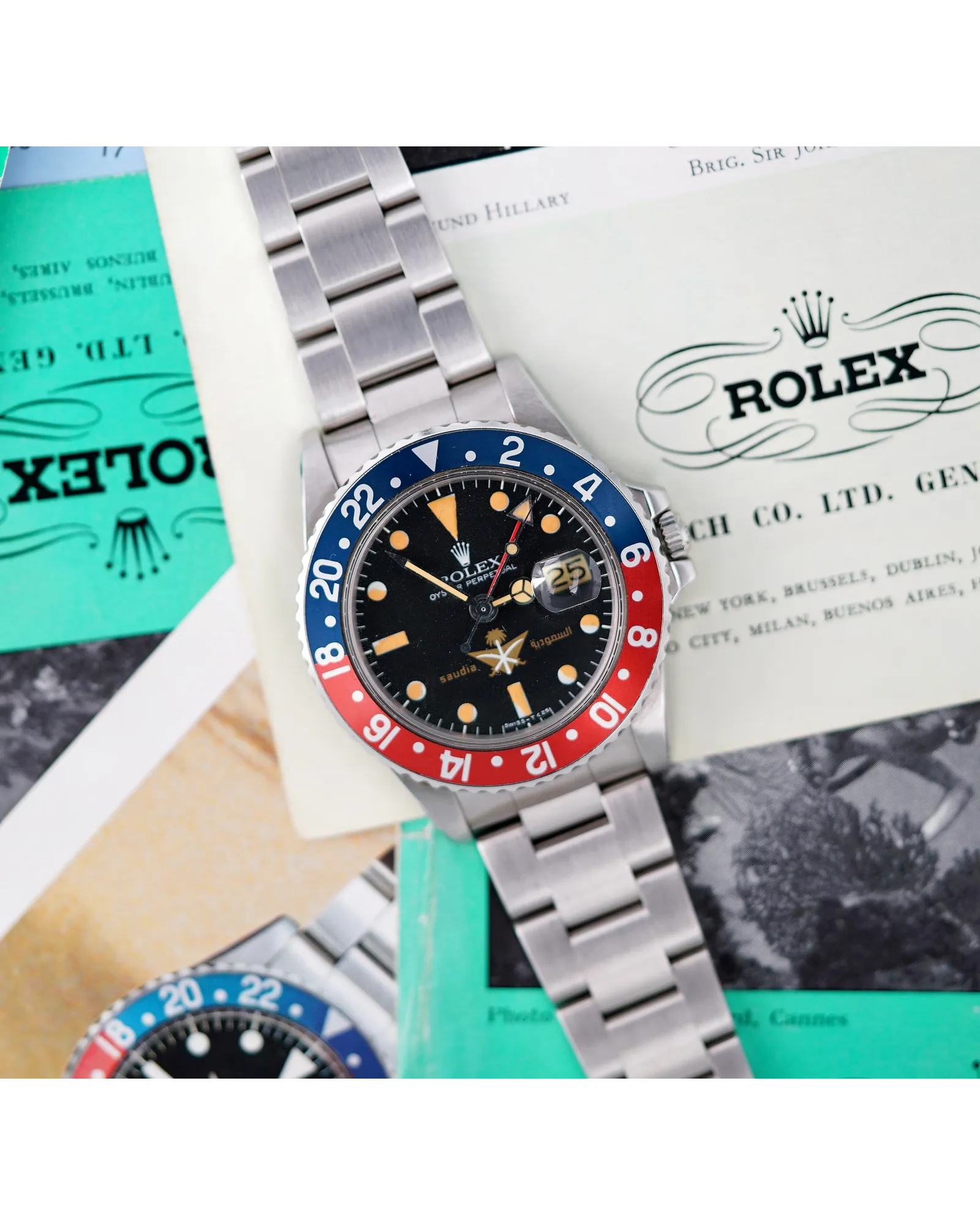 Flat-lay shot of vintage Rolex GMT-Master with faded blue and red bezel, tropical dial, and original papers.