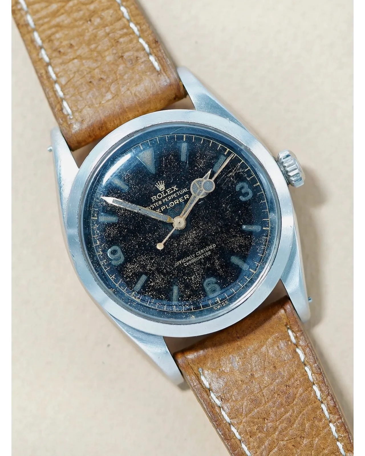 Dial detail of a Rolex Oyster Perpetual Explorer with aged black gilt dial on tan leather strap.