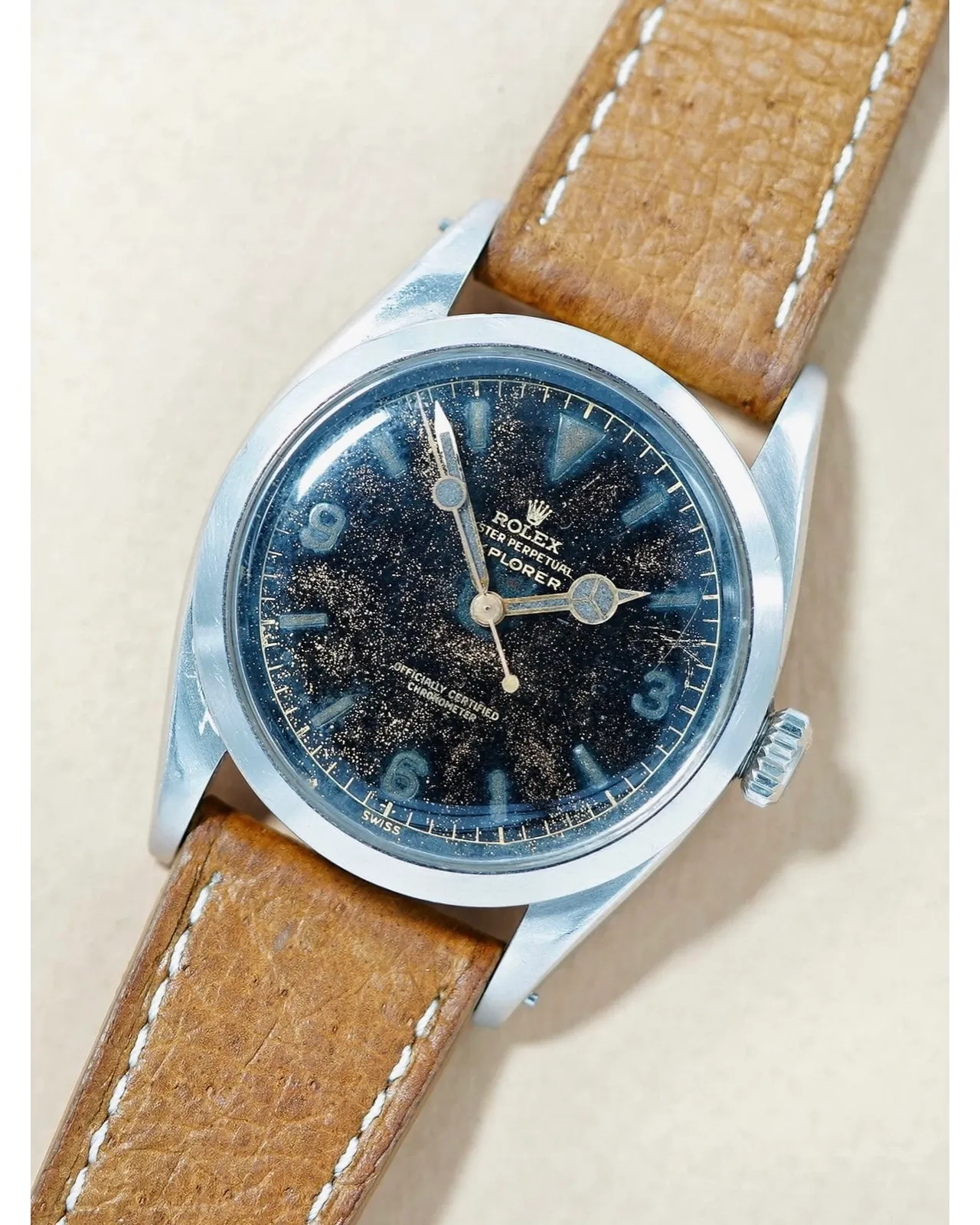 Dial detail of a vintage Rolex Explorer with tropical gilt patina on tan leather strap.