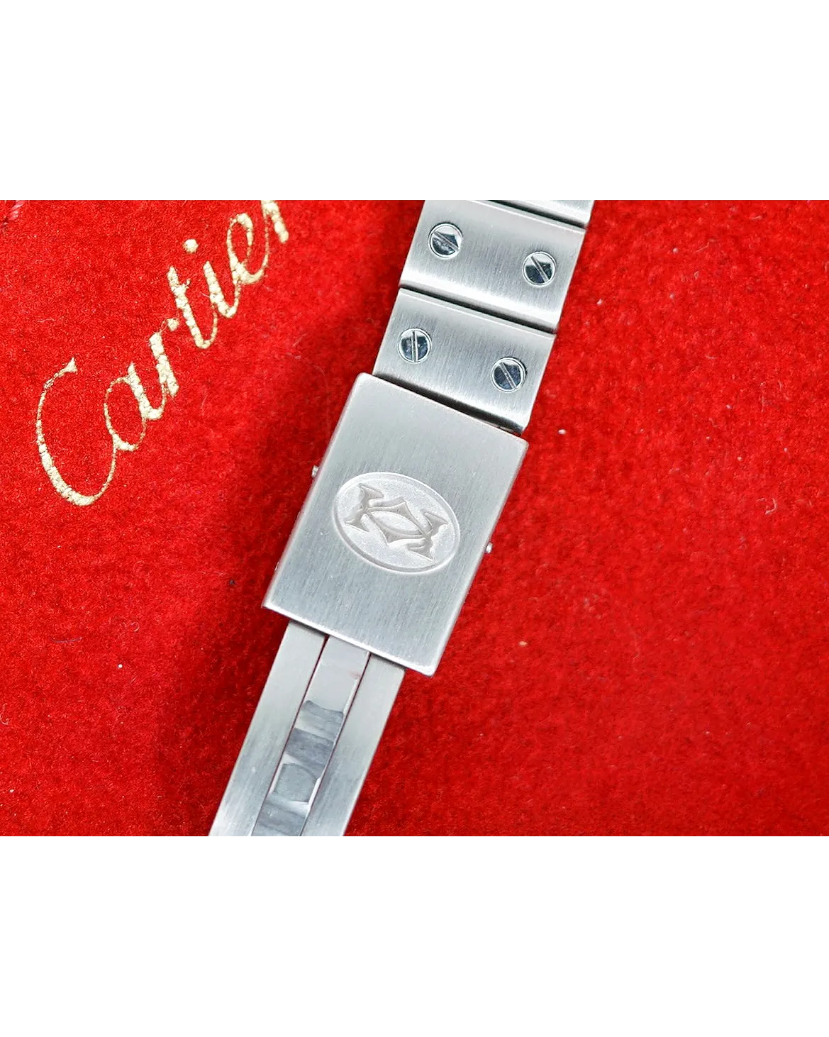 Bracelet clasp detail of a Cartier watch with screw decoration and engraved double-C logo on brushed steel.