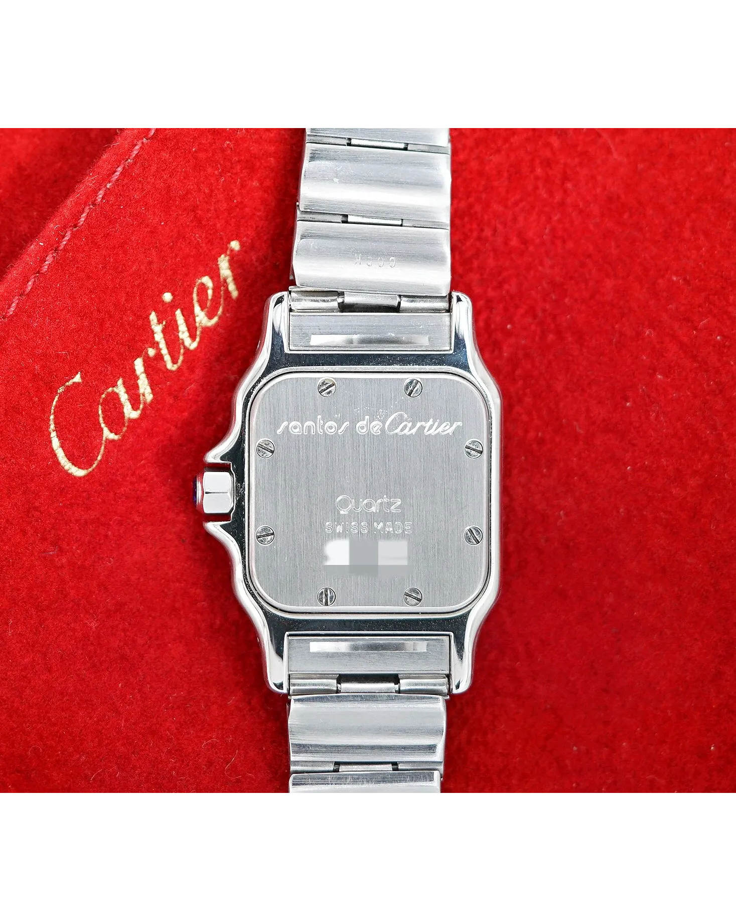 Caseback view of a Santos de Cartier quartz watch showing brushed steel case with screws and Swiss Made engraving.