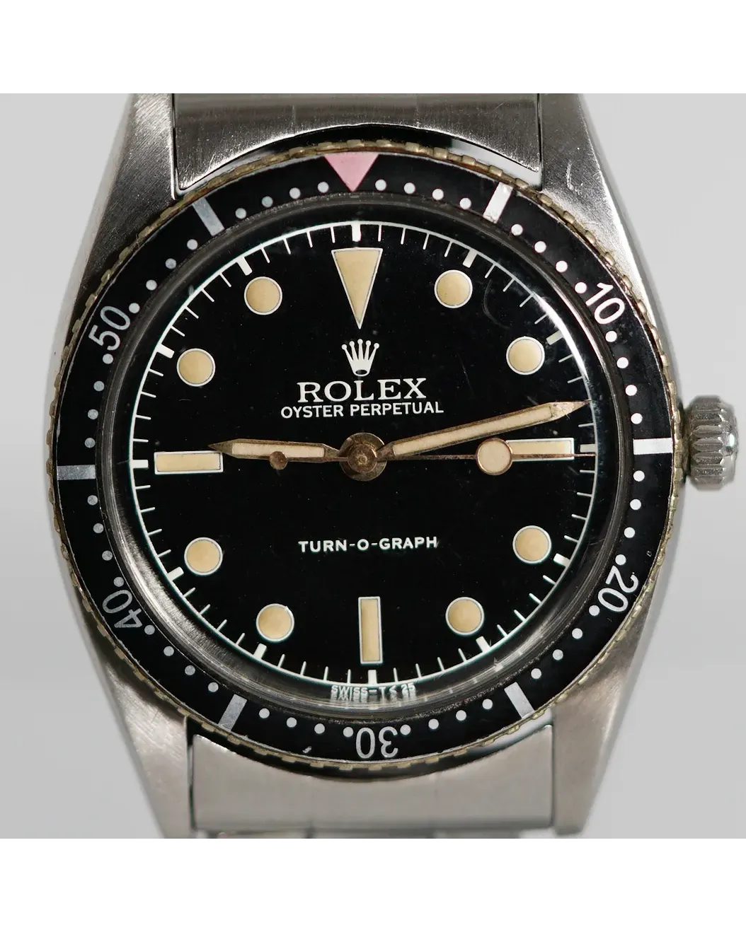 Dial detail of a Rolex Oyster Perpetual Turn-O-Graph 6202 showing black dial with patinated hour markers and bezel.