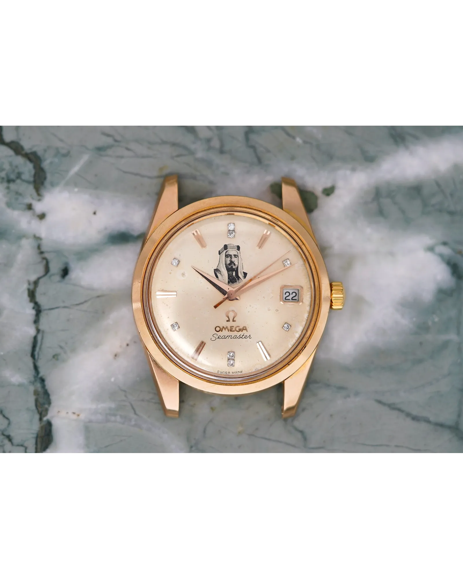 Dial detail of an Omega Seamaster in rose gold with portrait motif, diamond indices, and date window.