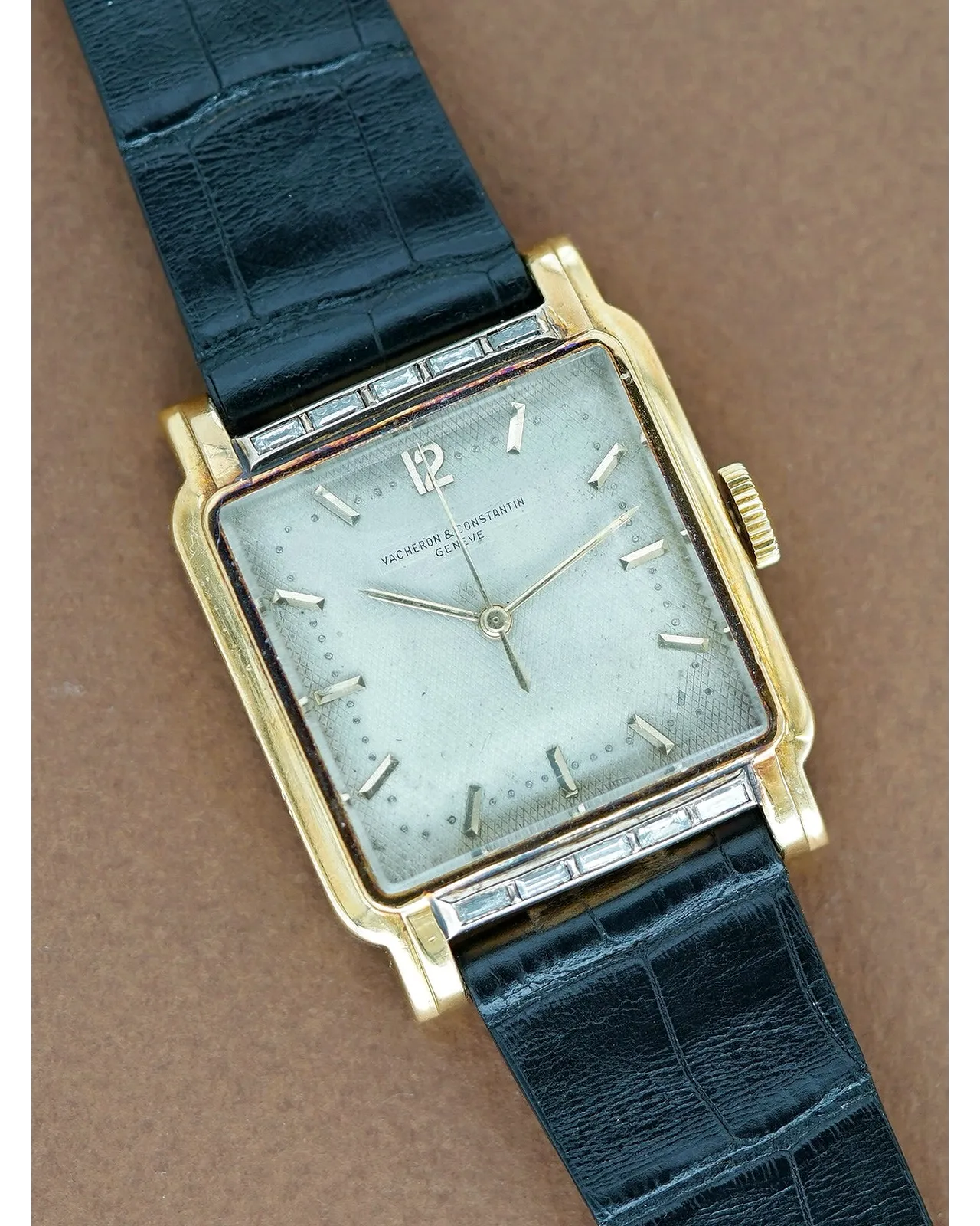 Dial detail of a Vacheron Constantin rectangular yellow gold watch with silvered dial and baguette diamond-set bezel.