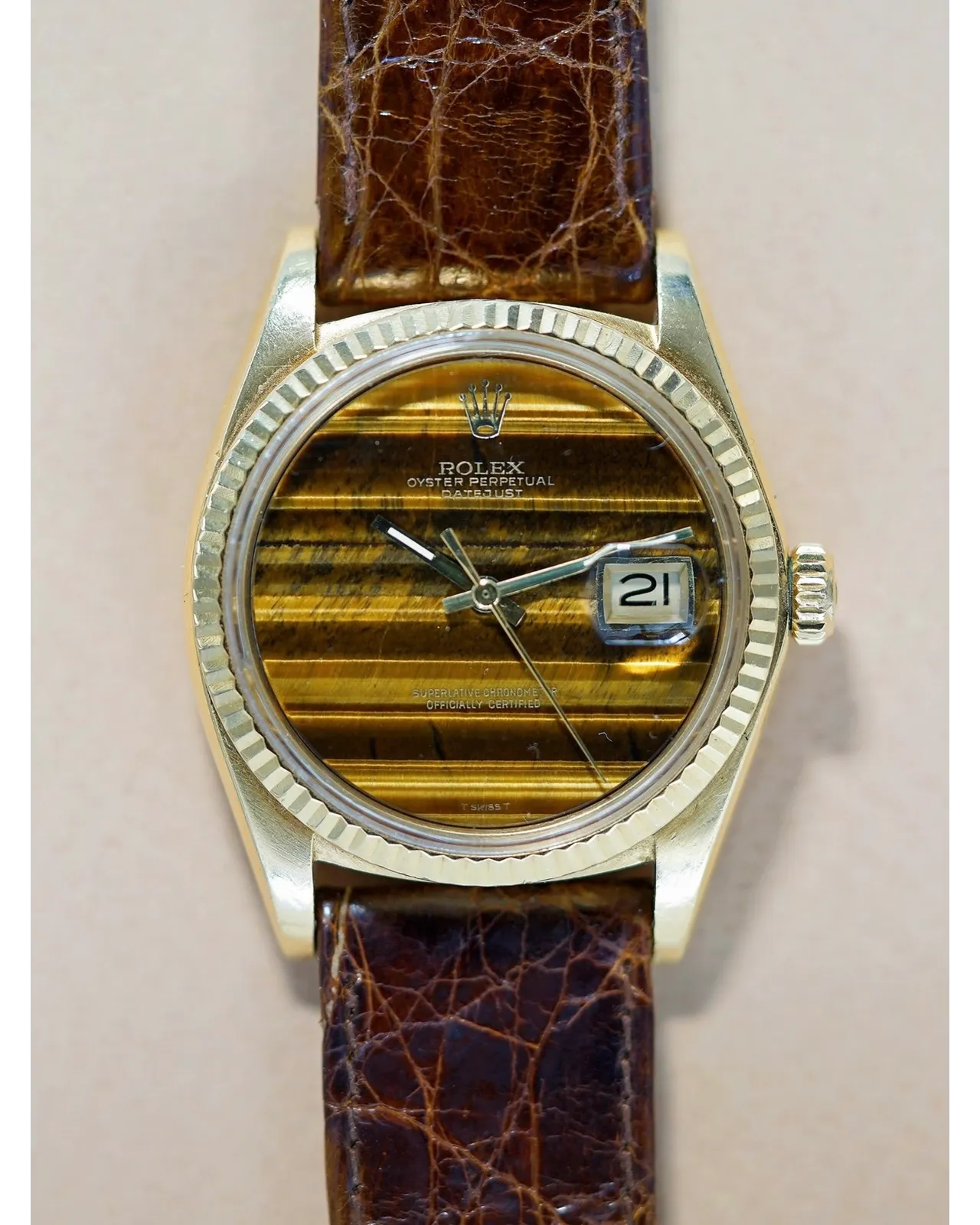 Dial detail of a Rolex Oyster Perpetual Datejust featuring a tiger's eye stone dial on brown leather strap.