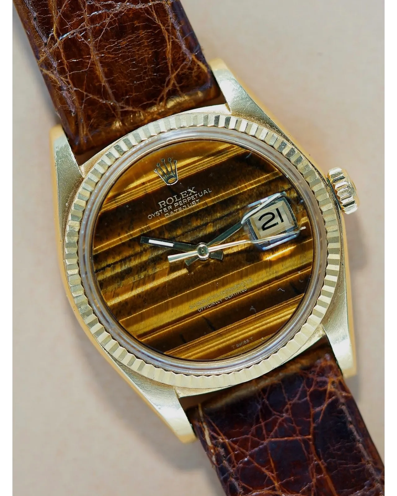 Dial detail of a Rolex Oyster Perpetual Datejust with tiger's eye stone dial and fluted bezel on leather strap.